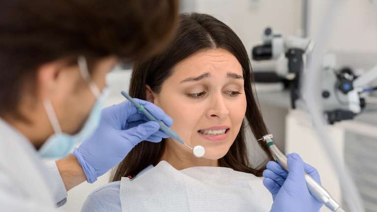 Woman with dental phobia sitting in dentist chair during check-up